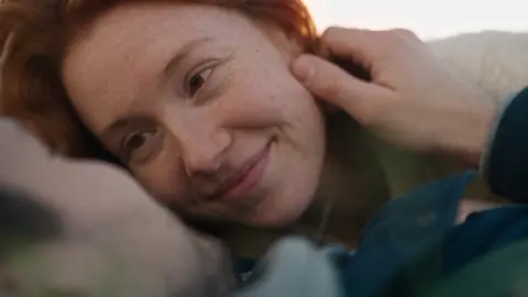 The memory: Hard cut: the same hug, alive, in a golden meadow.